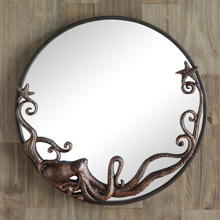 a mirror with an octopus on it is hanging on the wall next to a wooden floor