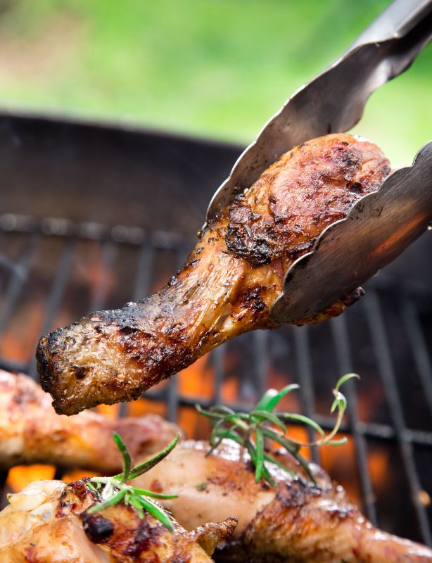 the meat is being grilled on the grill with tongs and garnishes