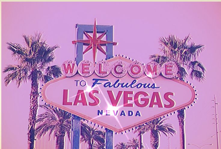 the welcome to fabulous las vegas sign with palm trees in the foreground and pink sky