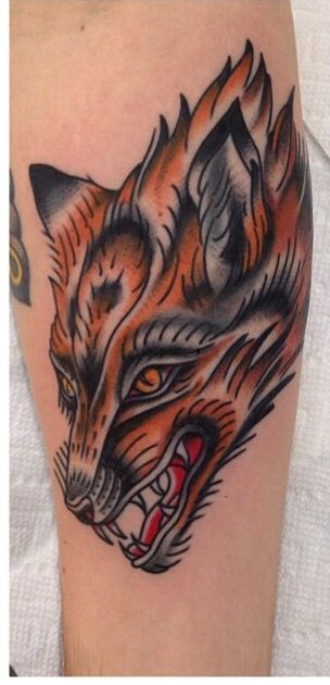 a close up of a tattoo on a person's leg with an orange and black fox