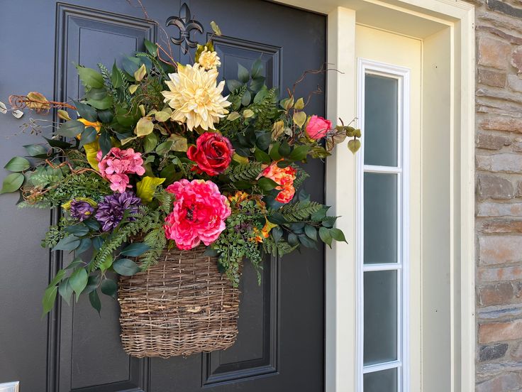 a basket filled with flowers hanging from the side of a door