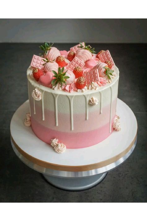 a pink and white cake with strawberries on top