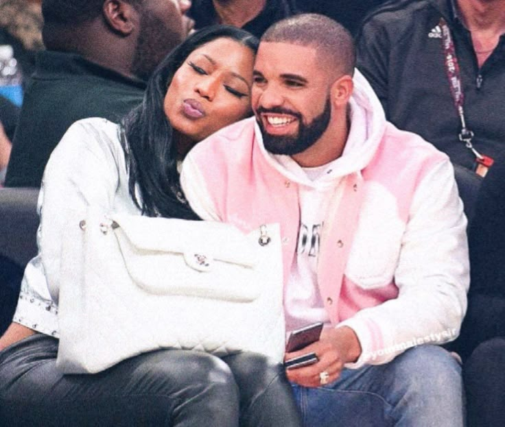 a man and woman sitting next to each other at a basketball game