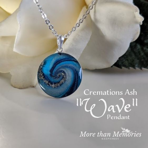 a necklace with a blue swirl design on it next to a white rose and the words creations ash if wave pendantt