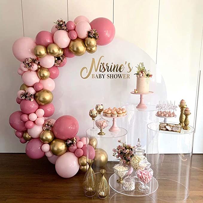 a table topped with lots of pink and gold balloons in front of a sign that says mrsine's baby shower