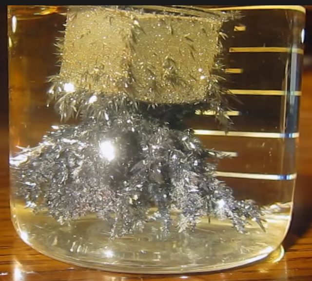 a glass jar filled with silver foil on top of a wooden table