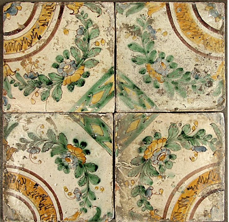 four tiles with different designs on them in the shape of flowers and leaves, all painted green