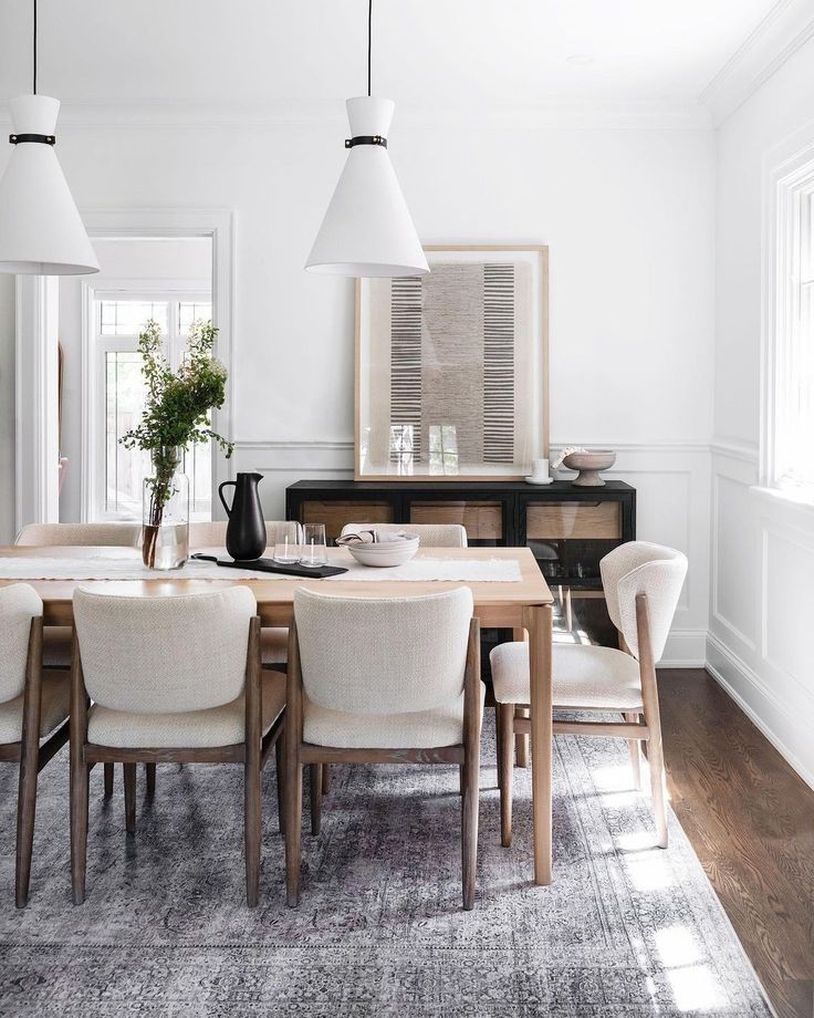 the dining room table is set with white chairs