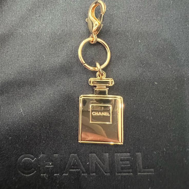 Authentic Chanel Perfume Keycharm From The Beauty Collection - New Double Sided With Chanel Stamped On Both Sides. Perfect For Keys Or To Add To A Bag. Will Include The Lariat Necklace With Purchase In Second Pic Also Adorable To Upcycle Into Jewelry For An Affordable Chanel Necklace, Chanel Earrings, Chanel Choker, Chanel Bracelet, Etc (See Examples! Not Included In Purchase Of Keycharm But Are For Sale On Our Site) Chanel Keychain Chanel Charm Elegant Pendant Charms With Logo, Elegant Pendant Logo Charm, Elegant Logo Charm Pendant, Elegant Gold Charms With Logo, Elegant Gold Charm With Logo, Elegant Gold Logo Charm, Luxury Gold Charms With Removable Details, Luxury Gold Charms With Removable Feature, Gold Logo Charm Bag Charm