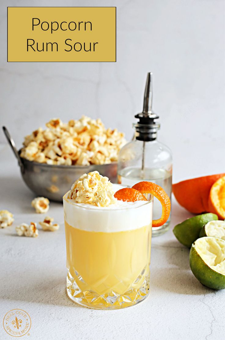 the popcorn rum sour cocktail is garnished with an orange slice