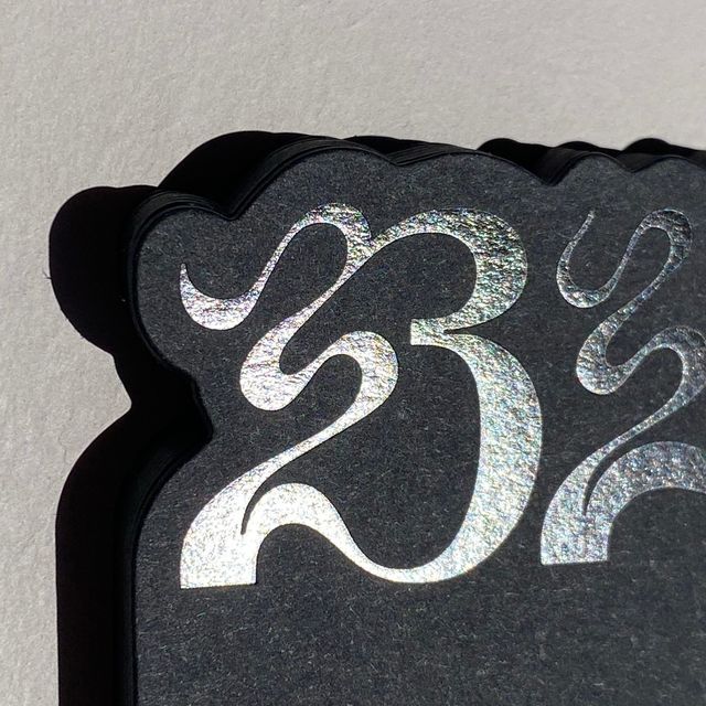 a black and silver sign with the number twenty five on it's back side