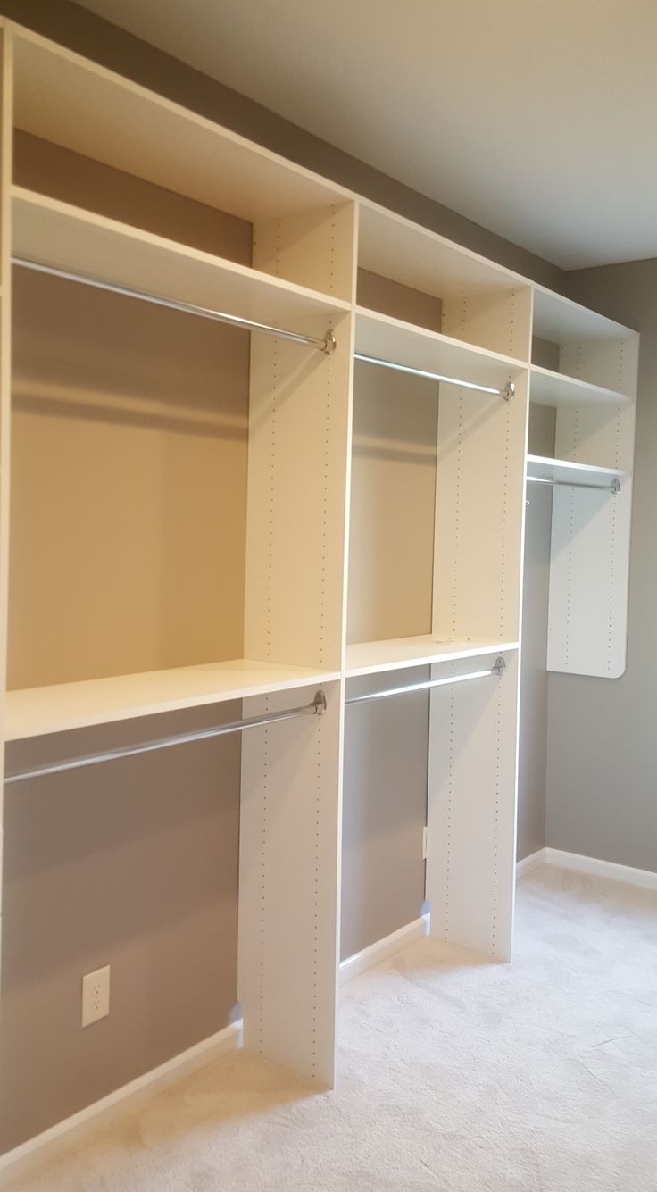 an empty room with white shelving in the middle and carpeting on the floor