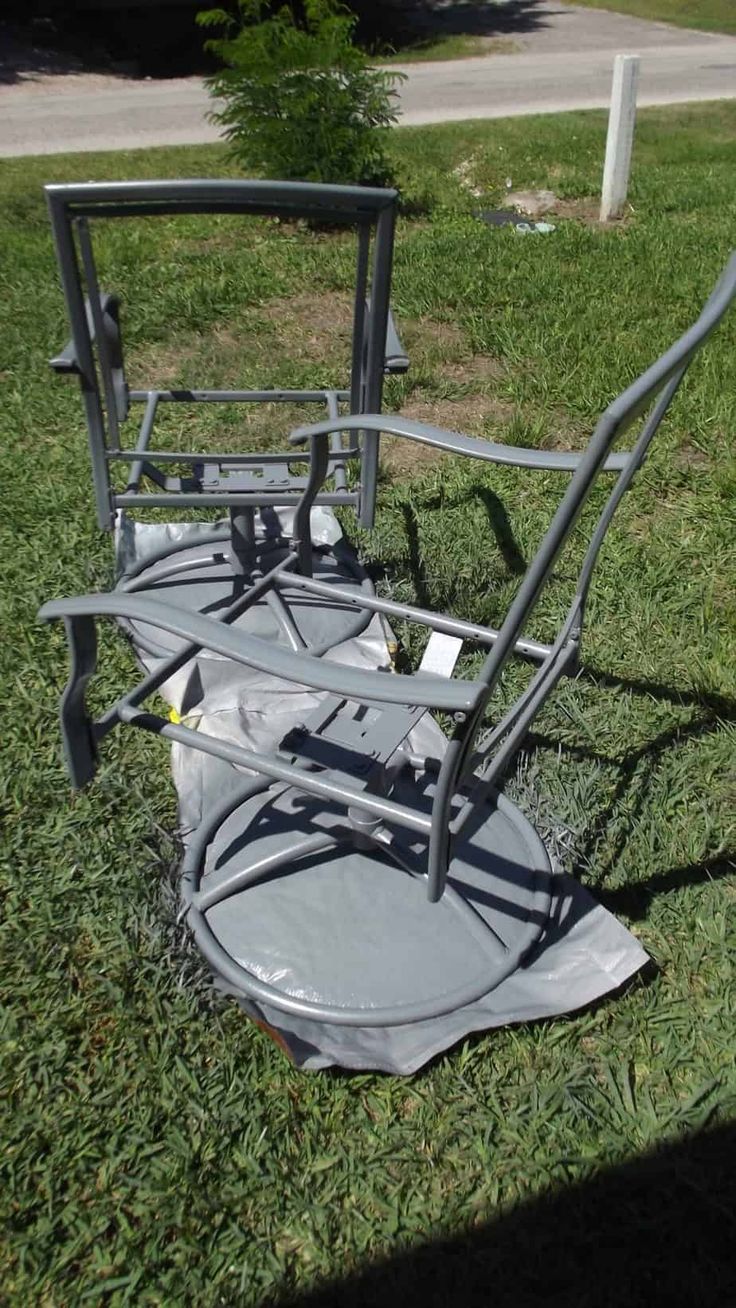 a metal chair sitting on top of a lush green field