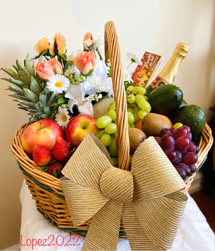 a wicker basket filled with assorted fruit and flowers