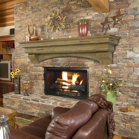 a living room with a fire place and couches in front of a stone fireplace