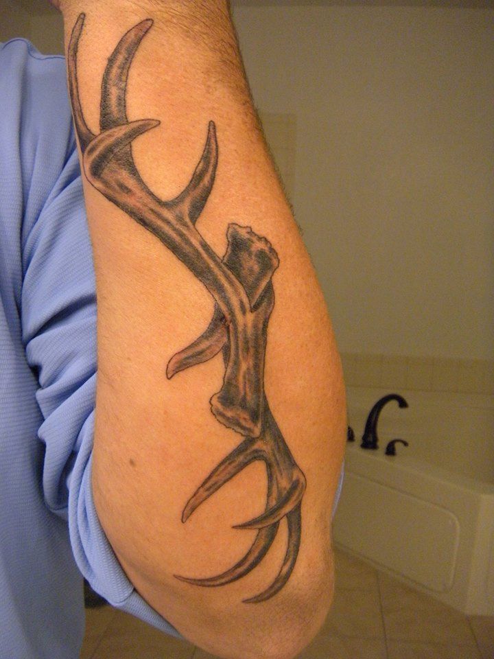 a man with a tattoo on his arm and the words antlers tattooed by nathan