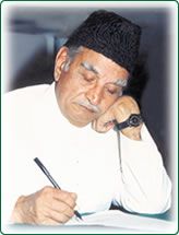 a man sitting at a table with a pen in his hand