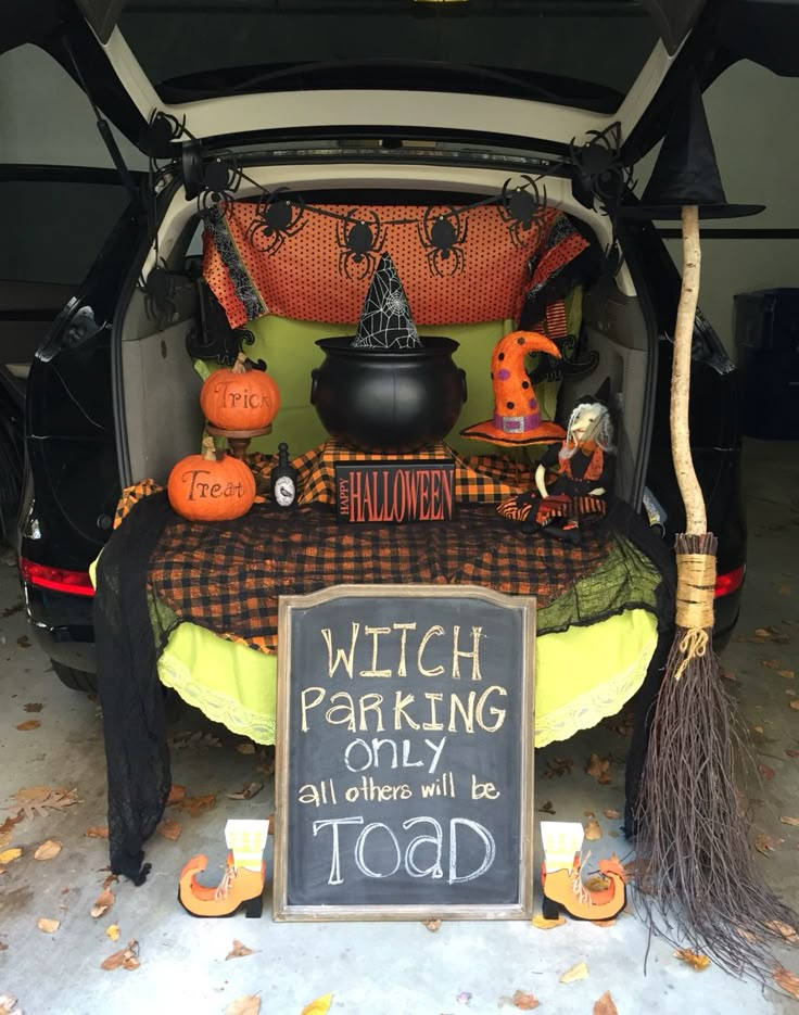 the trunk of a car is decorated with halloween decorations and witch's hat, brooms, and a sign that says witch parking only all others will be toad