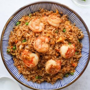 a bowl filled with rice and shrimp on top of a table