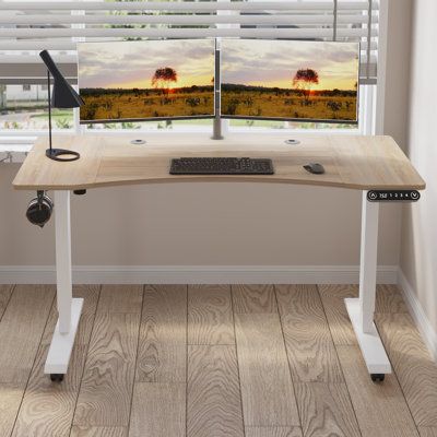 a computer desk sitting in front of a window with two monitors on top of it