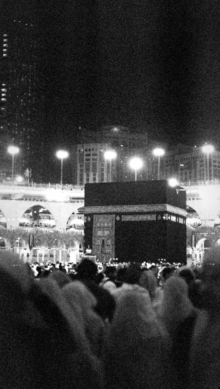 a crowd of people standing in front of a building at night