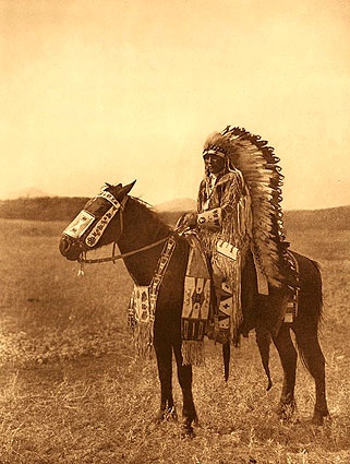 an old photo of a native american man on a horse