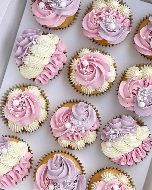 cupcakes with pink and white frosting in a box