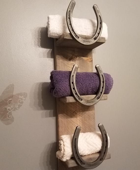 two horseshoes are hanging on the wall with towels