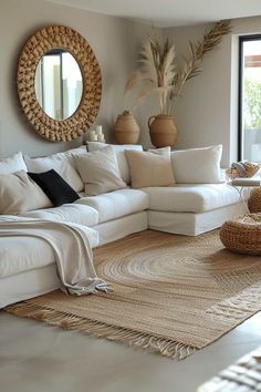 a living room filled with lots of white furniture and pillows on top of a rug