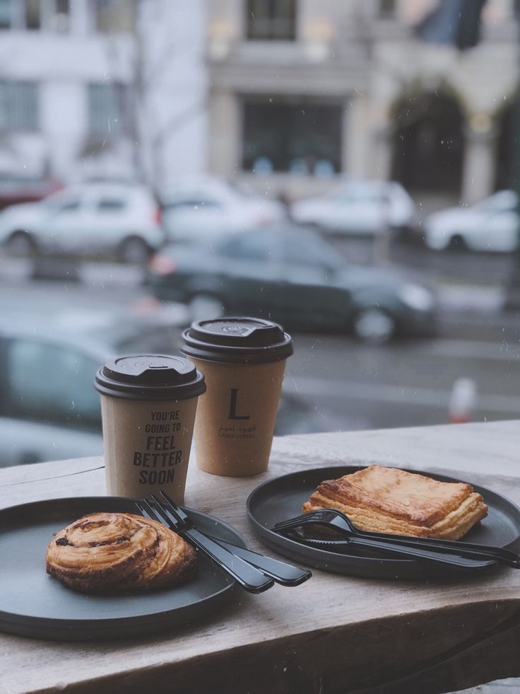 two black plates topped with food next to a cup of coffee