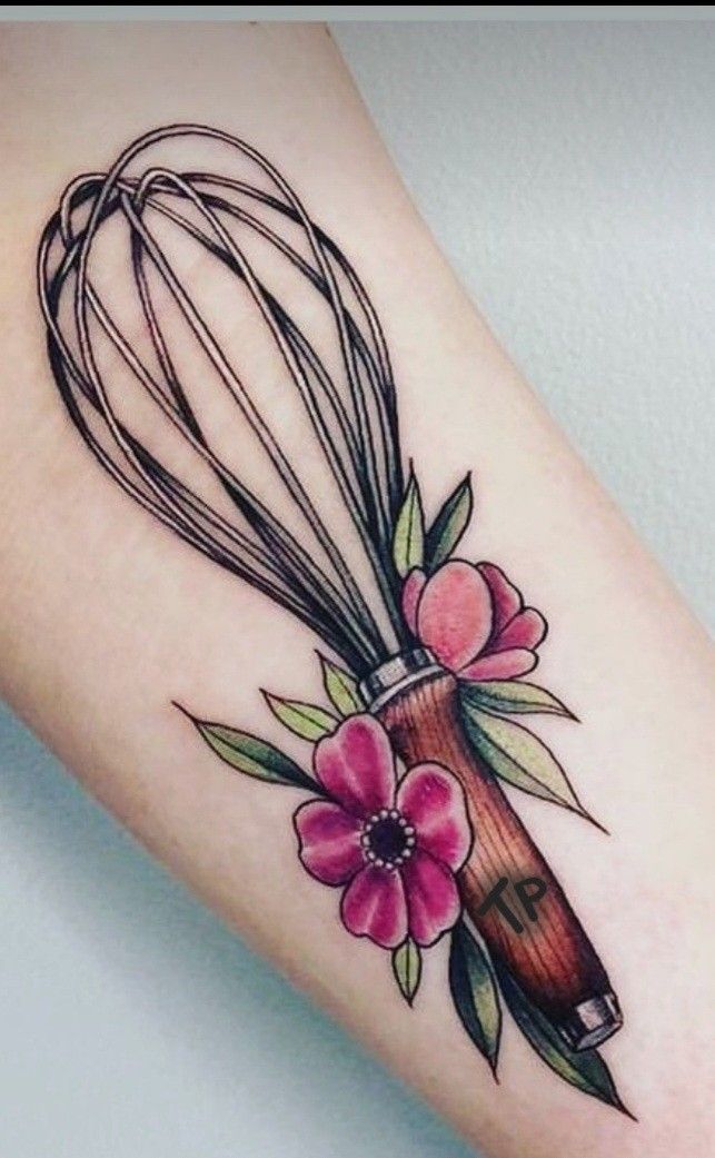 a tattoo with a whisk and flowers on it