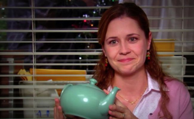 a woman holding a teapot in front of her face