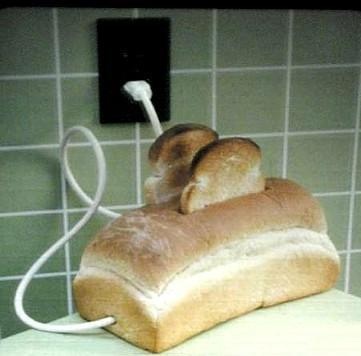 a loaf of bread is plugged in to a wall charger on a counter