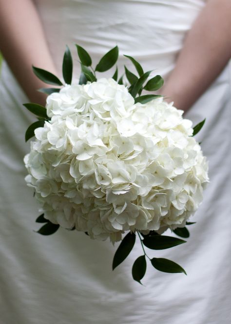 a bride holding a bouquet of white flowers