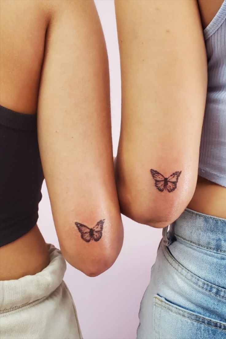 two women with butterfly tattoos on their bodies, one is holding the other's butts