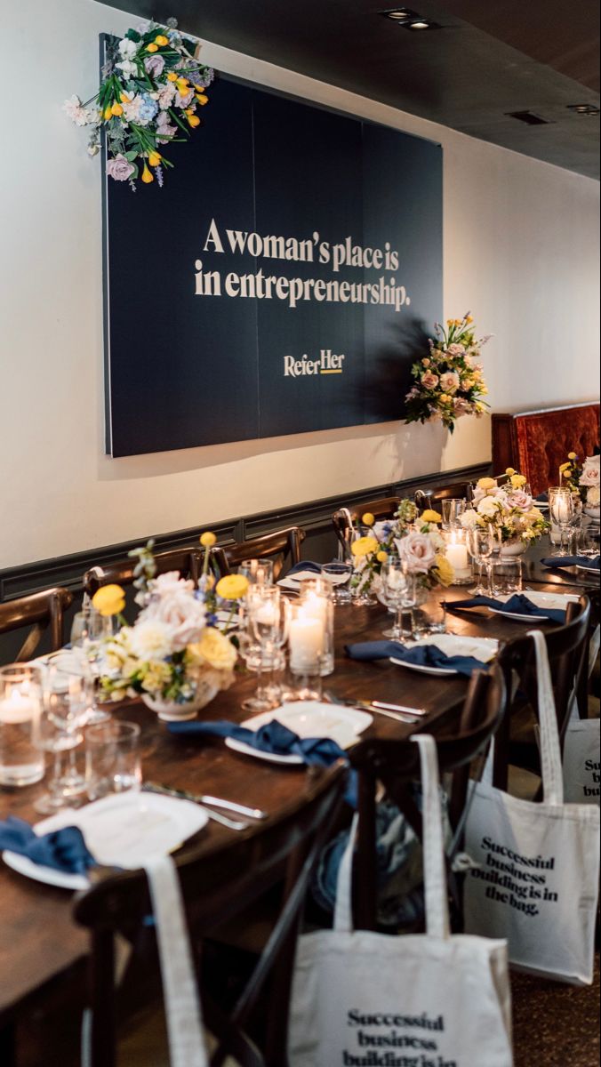 a long table is set up with white and blue napkins, candles, and flowers