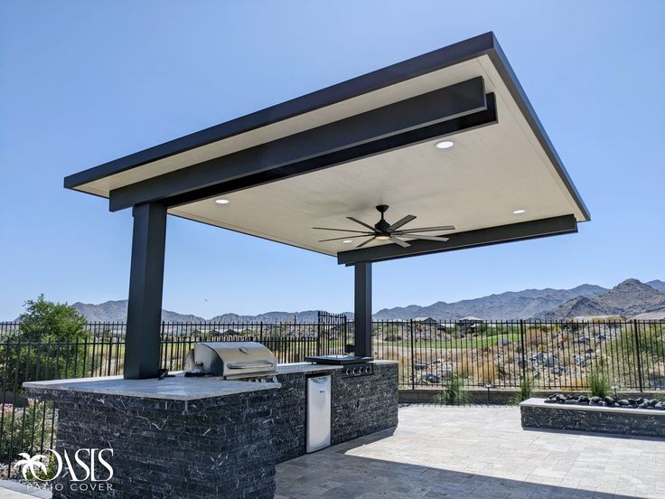 an outdoor grill area with a ceiling fan