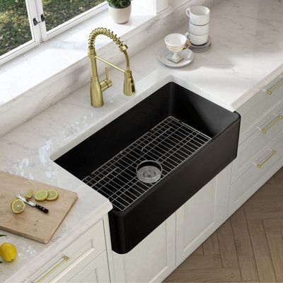 a kitchen sink sitting under a window next to a cutting board with lemons on it