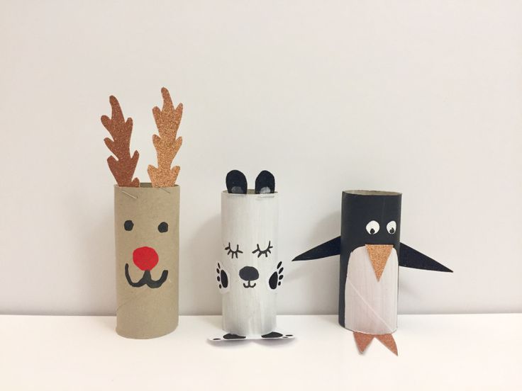 three paper mache animals are standing next to each other on a white surface, one is wearing a santa hat and the other has reindeer's nose