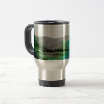 a travel mug with mountains in the background