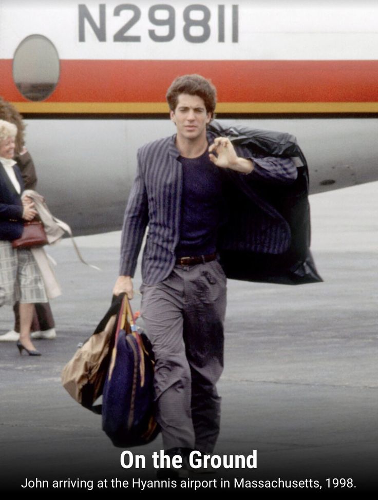 a man walking towards an airplane carrying luggage