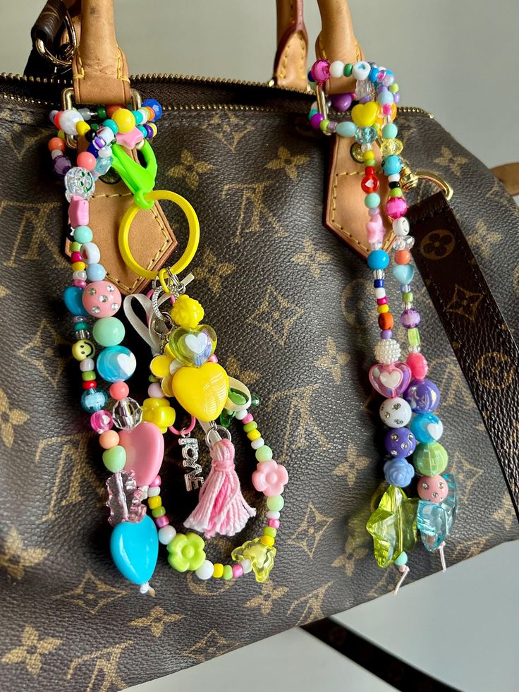 a handbag is decorated with colorful beads and charms on it's handle,