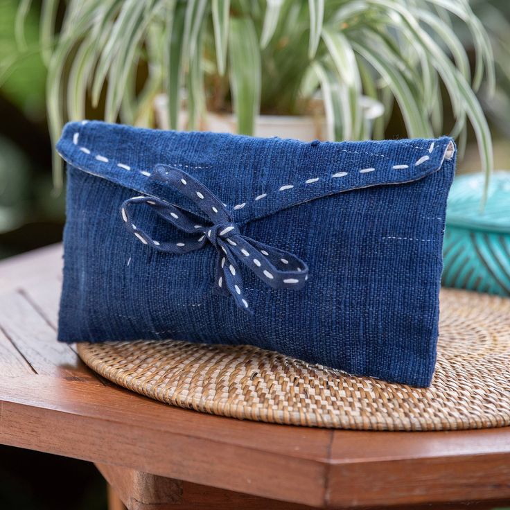 Handwoven by Balinese artisans, Elizabeth Selly's newest creation is a convenient accessory intended to help you with your makeup articles and personal items. Made from cotton, this cosmetic bag comes in a chic blue hue with little white stitch accents that enhance the design's elegant style. Furthermore, it features a tie closure that will keep everything in place and secure. Blue Bag With Zipper Pouch As Gift, Blue Rectangular Pouch For Personal Use, Rectangular Blue Pouch For Personal Use, Blue Clutch Cosmetic Bag For Daily Use, Blue Clutch Cosmetic Bag For Travel, Handmade Blue Rectangular Pouch, Handmade Blue Travel Pouch, Artisan Blue Bag For Gift, Handmade Blue Cosmetic Bag For Gift