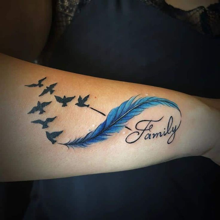 a woman's arm with a blue feather and the word family written on it