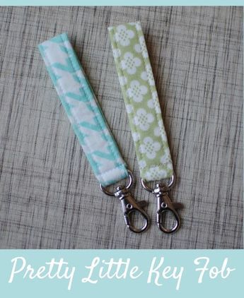 two green and white lanyards with silver metal clippings on fabric background