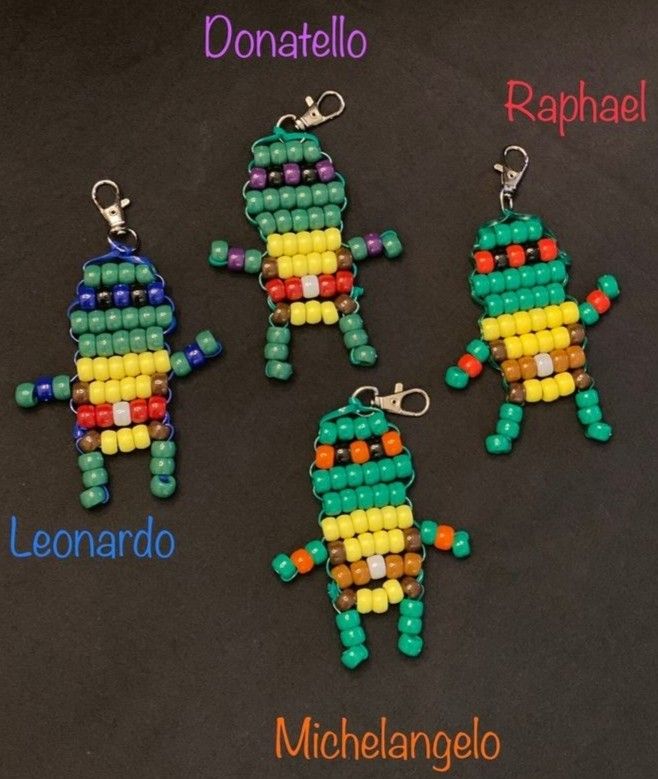 four beaded keychains with different colors and designs on them, including one in the shape of a robot