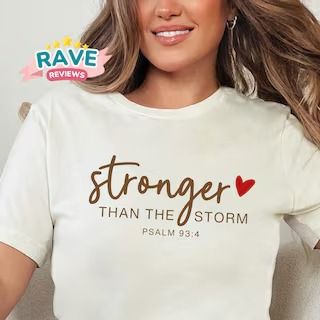 a woman wearing a t - shirt that says, stronger than the storm