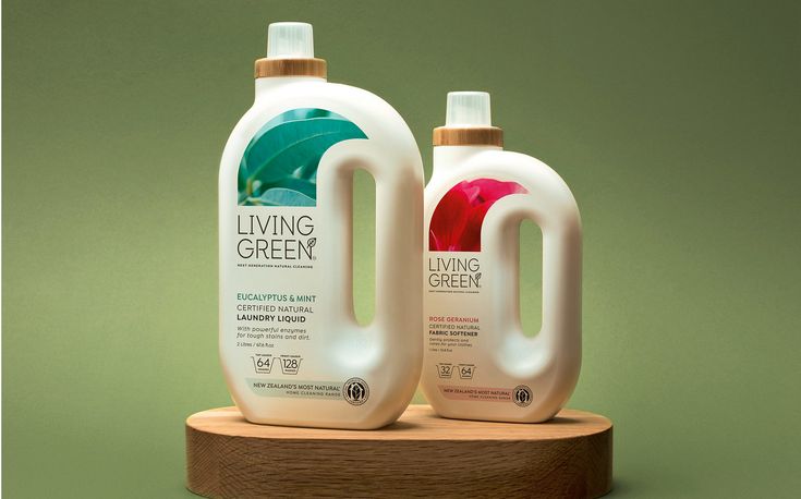 two bottles of living green liquid sitting on top of a wooden stand against a green background