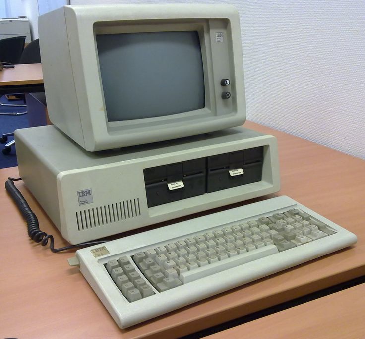 an old computer sitting on top of a wooden desk