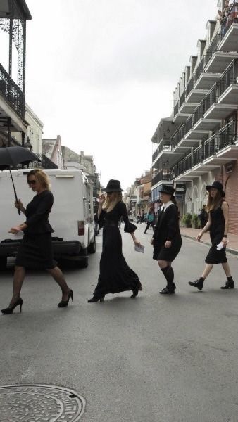 four women walking down the street with an umbrella